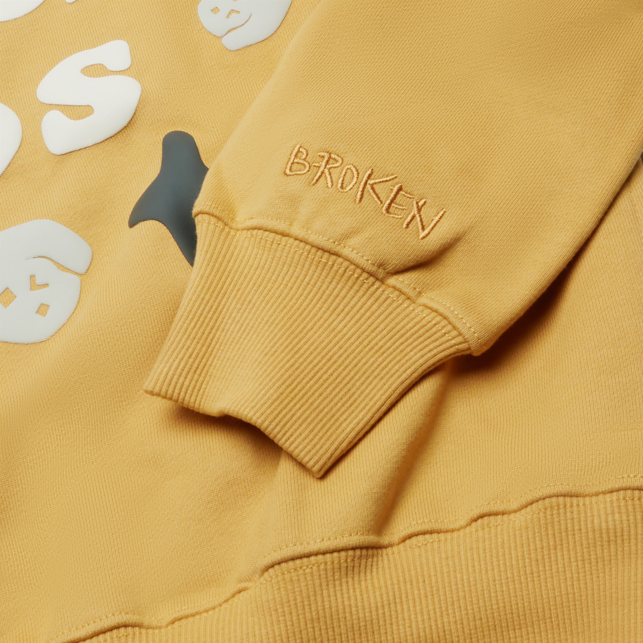 Sleeve view of Broken Planet So Much Chaos Mustard Yellow Hoodie BP-SMC-HD-MUSTARD